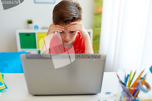 Image of tired student boy with laptop computer at home