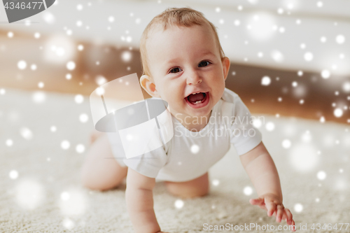 Image of little baby in diaper crawling on floor at home