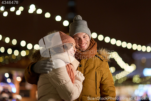 Image of happy couple hugging at christmas tree