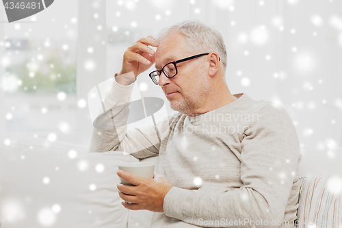 Image of senior man with cup of tea at home