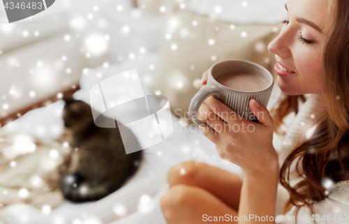 Image of close up of happy woman with cup of cocoa at home