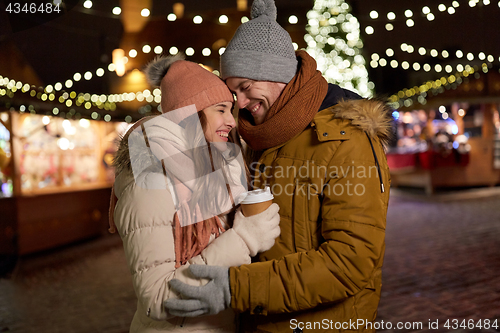 Image of happy young couple with coffee at christmas market