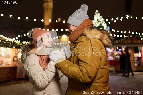 Image of happy couple holding hands at christmas market