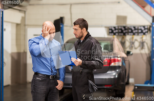 Image of auto mechanic and customer at car shop