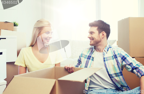 Image of smiling couple with many boxes moving to new home