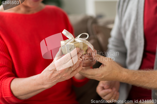 Image of close up of senior couple with christmas gift