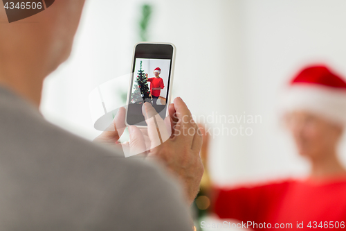 Image of close up of senior man picturing wife at christmas