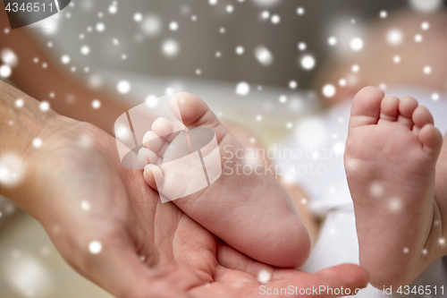 Image of close up of newborn baby feet in mother hands