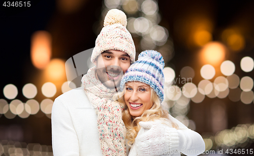 Image of happy couple hugging over christmas lights