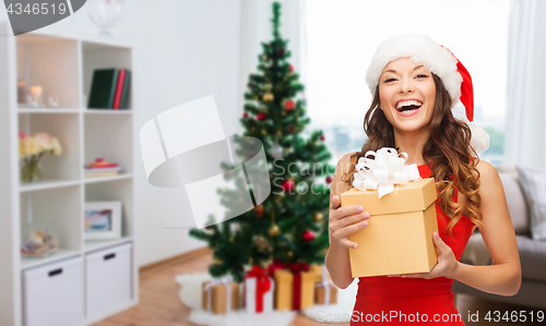 Image of smiling woman in santa hat with christmas gift