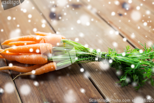 Image of close up of carrot bunch on wooden table