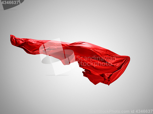 Image of Smooth elegant transparent red cloth separated on gray background.