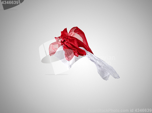 Image of Smooth elegant transparent red and white cloth separated on gray background.