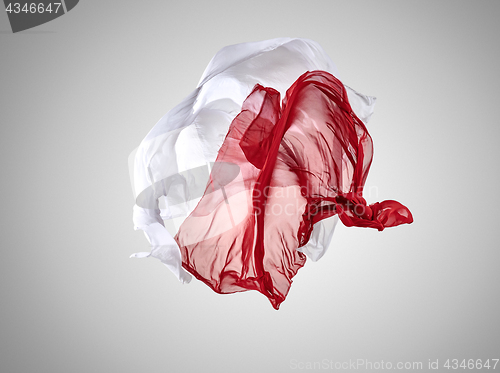 Image of Smooth elegant transparent red and white cloth separated on gray background.