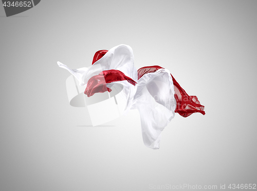 Image of Smooth elegant transparent red and white cloth separated on gray background.