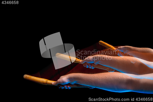 Image of The arm with wooden baseball bat on black background