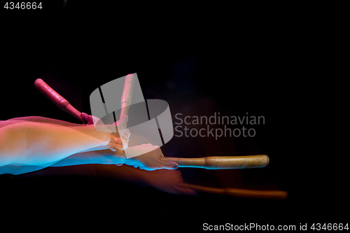 Image of The arm with wooden baseball bat on black background