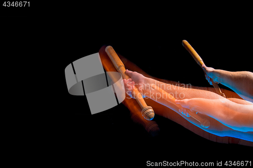 Image of The arm with wooden baseball bat on black background