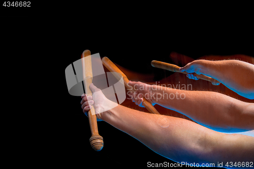 Image of The arm with wooden baseball bat on black background