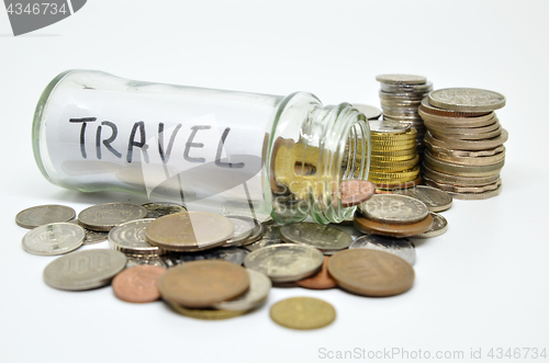 Image of Travel lable in a glass jar with coins spilling out