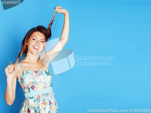 Image of young pretty woman fooling around on blue background