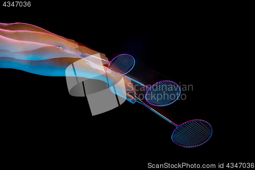 Image of The hands of young man playing badminton over black background