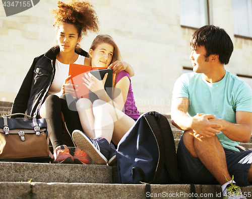 Image of cute group of teenages at the building of university with books huggings, back to school