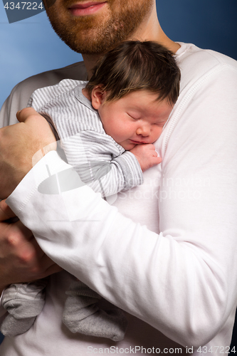 Image of Portrait of young happy couple embracing to their newborn.