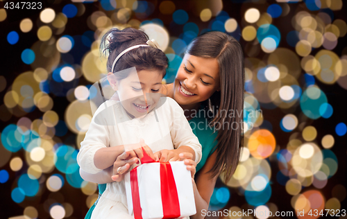 Image of happy mother and daughter girl with gift box