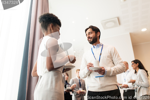 Image of business people with conference badges and coffee