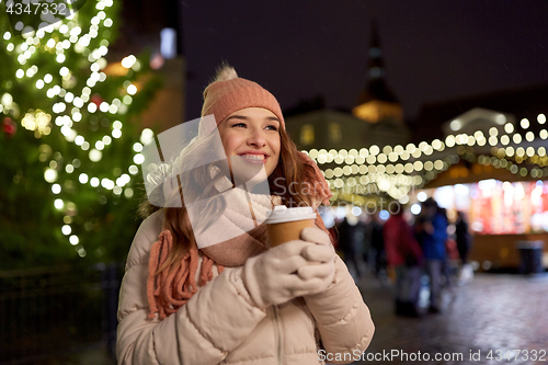 Image of happy young woman with coffee at christmas market