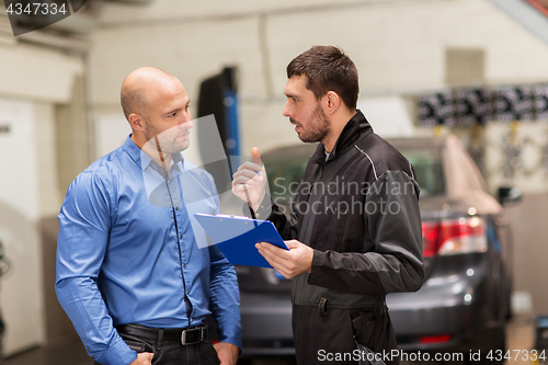 Image of auto mechanic and customer at car shop