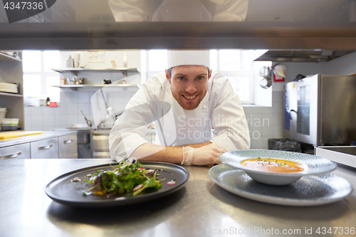 Image of happy male chef cooking food at restaurant kitchen