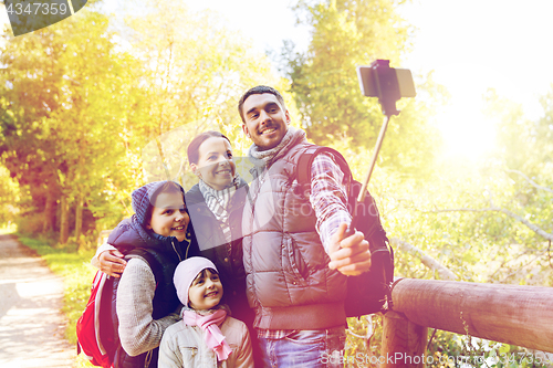 Image of family with backpacks taking selfie and hiking