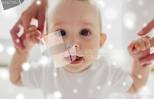 Image of happy baby learning to walk with mother help