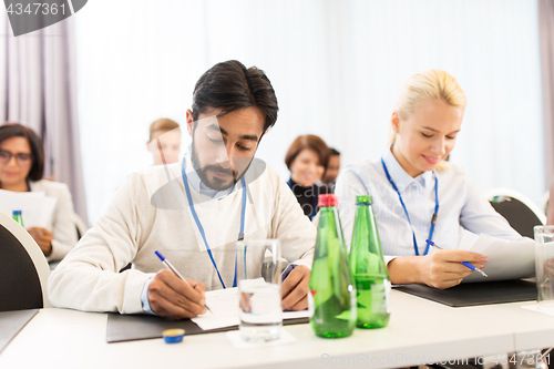 Image of businesspeople with papers at conference