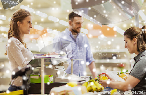 Image of couple buying food at grocery store cash register