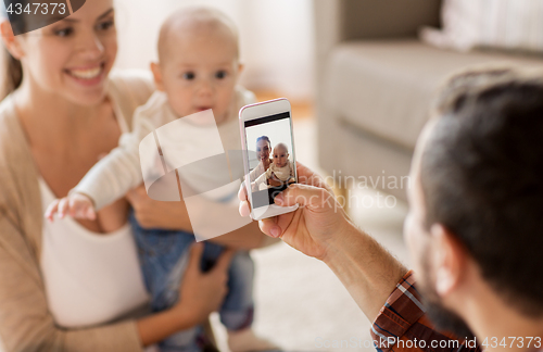 Image of happy family with baby photographing at home