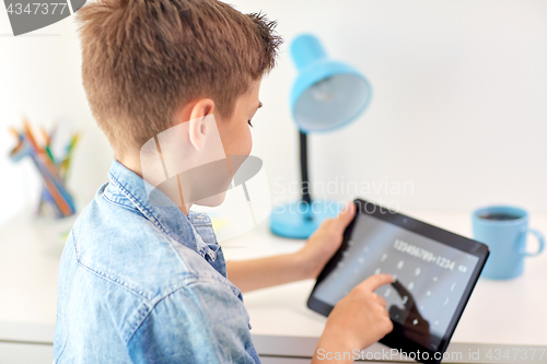 Image of student boy counting on tablet pc calculator