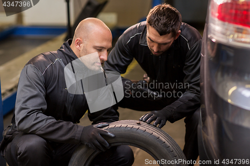 Image of auto mechanics changing car tires at workshop