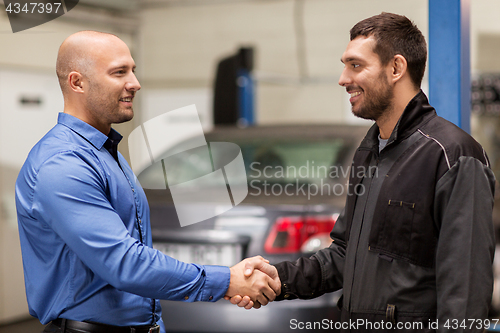 Image of mechanic and customer shaking hands at car service