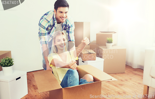 Image of happy couple having fun with boxes at new home