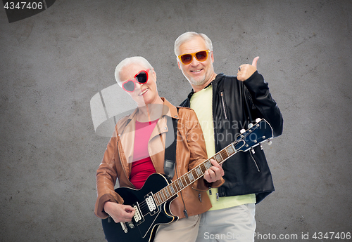 Image of happy senior couple with guitar showing thumbs up