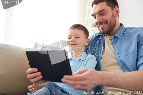 Image of father and son with tablet pc playing at home