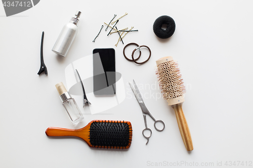 Image of smartphone, scissors, brushes and other hair tools