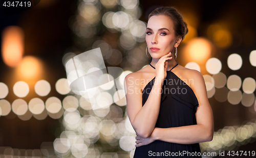 Image of woman wearing jewelry over christmas lights