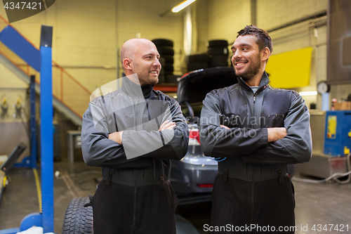 Image of auto mechanics or tire changers at car shop