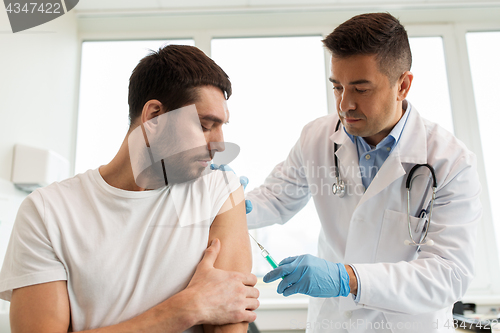 Image of patient and doctor with syringe doing vaccination