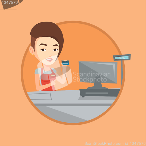 Image of Cashier holding credit card at the checkout.