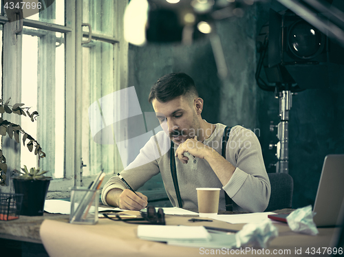 Image of Architect working on drawing table in office